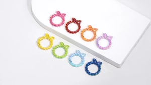 Anelli a molla a forma di fiocco in colori arcobaleno metallizzati su basi bianche
