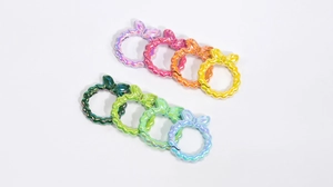 Dettaglio di 8 moschettoni a anello a forma di fiocco in colori metallici sfumati