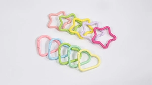 Dettaglio di moschettoni colorati opachi a forma di cuore e stella per accessori fai-da-te