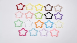 Vista piatta di moschettoni colorati a forma di stella in vari colori laccati