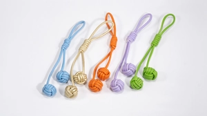 Détail de cinq nœuds en cuir tissés main et glands sphériques sur des porte-clés colorés