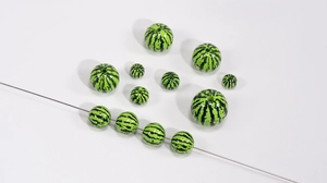 Macro view of acrylic watermelon pattern round beads in various sizes for DIY crafts