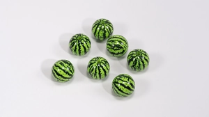 Macro shot of 7 acrylic beads with watermelon print texture for DIY jewelry making