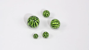 Detailed view of green striped acrylic watermelon beads with pre-drilled holes for DIY
