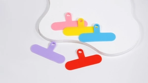 Close-up of five colorful T-shaped phone lanyard connector pads in a flat layout