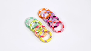 Set of eight colorful round spring buckles with contrast speckled patterns on white surface