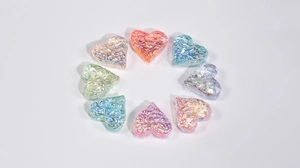 Macro shot of colorful iridescent heart beads with textured ice effect for DIY jewelry