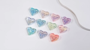Macro detail of heart-shaped macaron beads with ripple texture and iridescent finish