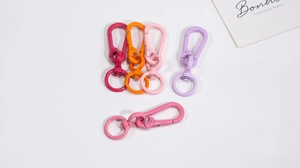 Detail of colorful metal lobster clasps and rings in glossy pink and purple finishes