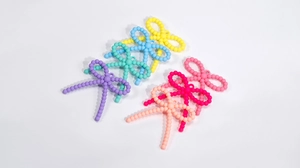 Macro detail of acrylic candy-colored twist bow beads for DIY jewelry making accessories