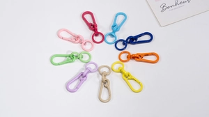 Detailed view of colorful lobster clasps with rotating rings in nine vibrant metallic finishes