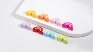 Close-up of colorful acrylic rainbow charms with polka dots and threading holes for DIY crafts