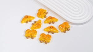 Detail shot of cute resin croissant and pretzel charms with smiling faces for DIY crafts