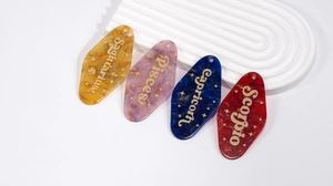 Detailed macro view of four colorful marble textured acrylic zodiac keychain charms