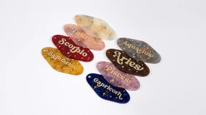 Detailed macro of vintage rhombic acrylic constellation charms with gold glitter lettering