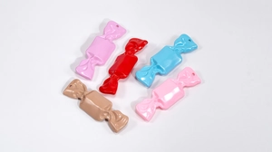 Close-up of five colorful acrylic candy pendants with small holes for DIY crafting