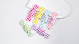Close-up of colorful acrylic candy pendants with lucky text and star patterns for DIY