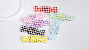 Close-up of colorful acrylic candy charms with checkered patterns and lucky text for DIY crafts