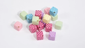 Detailed view of colorful acrylic square beads with polka dots for DIY jewelry making