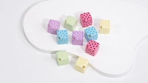 Detailed view of colorful macaron acrylic cube beads with polka dots for DIY jewelry
