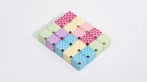 Close-up of colorful acrylic square beads with polka dots and center holes for DIY