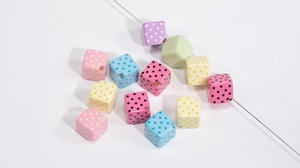 Close-up of colorful acrylic cube beads with polka dot patterns for DIY jewelry making