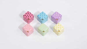 Close-up detail of colorful acrylic cube beads with polka dot patterns for DIY jewelry