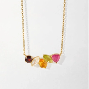 Detail of gold necklace featuring five colorful multi-shape gemstones on a fine chain link
