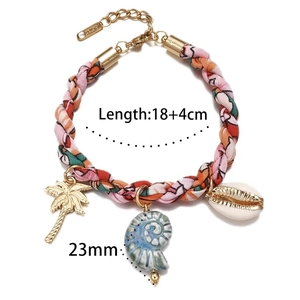 Détail macro du bracelet en corde tressée avec breloques palmier doré et coquillages