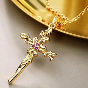 Vue macro du pendentif croix en or 18K avec quatre pierres violettes et relief floral