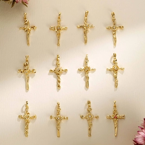 Vue macro de 12 pendentifs croix dorés avec des sculptures florales délicates et raffinées