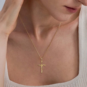 Détail du collier croix florale plaqué or 18 carats sur un modèle avec gros plan du pendentif