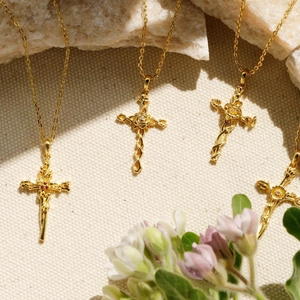 Détail macro du pendentif croix fleurie plaqué or 18K avec gaufrage de vignes