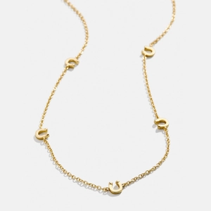 Collier minimaliste en acier titane doré avec cinq breloques fer à cheval polies