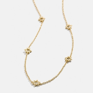 Vue détaillée du collier en acier titane doré avec pendentifs étoile à six branches sur blanc