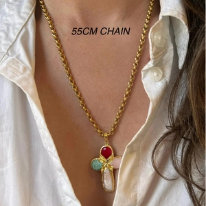 Detail of 55cm chain and cross pendant with colorful gemstone inlay on white shirt
