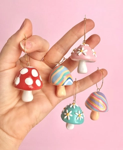 Detail showing oversized mushroom hoop earrings in various colors and hand-painted patterns