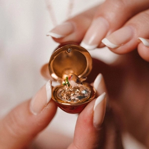 Pendentif œuf en émail rouge style Fabergé avec oiseau miniature et chaîne dorée