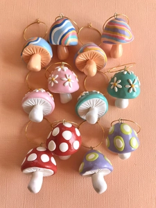 Detailed overhead view of assorted handmade clay mushroom earrings with colorful patterns