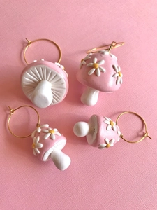 Detail of handmade 3D pink mushroom earrings with white daisy patterns and gold hoops