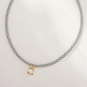 Detail of square claw-set pendant with round clear zircon and colorful woven cord necklace