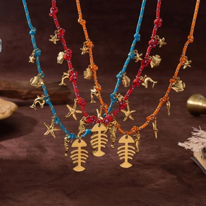 Detail of colorful woven ocean necklaces with golden fishbone and starfish charms
