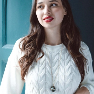 Collier vintage plaqué or avec pendentif œuf sombre sur un modèle en pull blanc