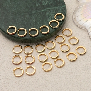 Close-up of gold-plated hoop earrings with vibrant colorful cubic zirconia inlays