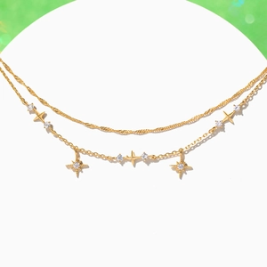 Nahaufnahme des goldene Doppelarmband mit Sternanhängern und funkelnden Zirkonia
