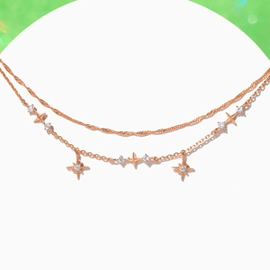 Detail eines roségoldenen zweilagigen Armbands mit Sternanhängern und Zirkonia