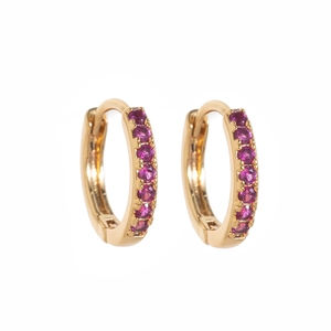 Detail view of 18k gold plated hoop earrings with channel set purple birthstone gems