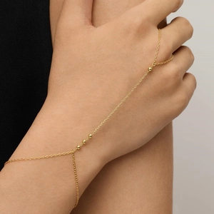 Detailed view of an elegant 18K gold-plated finger bracelet with minimalist gold beads