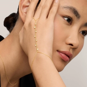 Detail of 18k gold plated stainless steel finger bracelet with sparkling round zircons