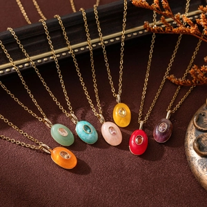 Detail of seven oval natural stone pendants in vibrant colors on gold chains